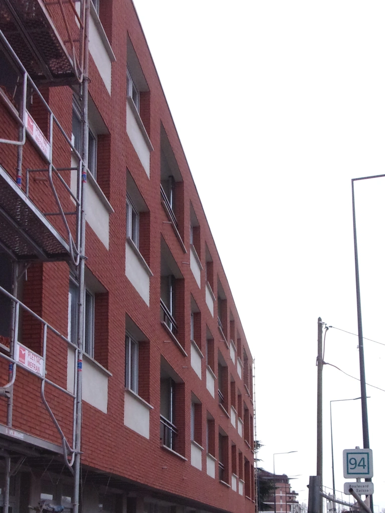 pose de briquettes de parement sur la façade principale d'un immeuble en construction à Toulouse - chantier réalisé par l'entreprise ASSO BÂT